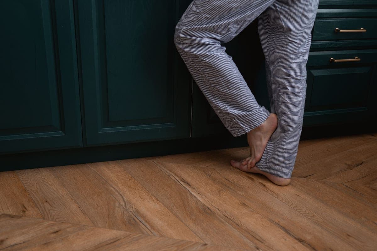 Bare feet standing on a wooden floor
