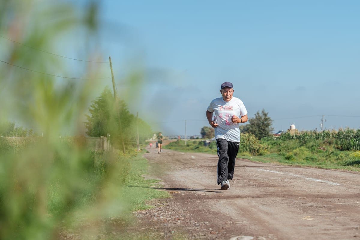 An older man jogging on a rural dirt road