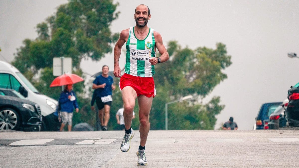 A smiling runner in a road race on a rainy day