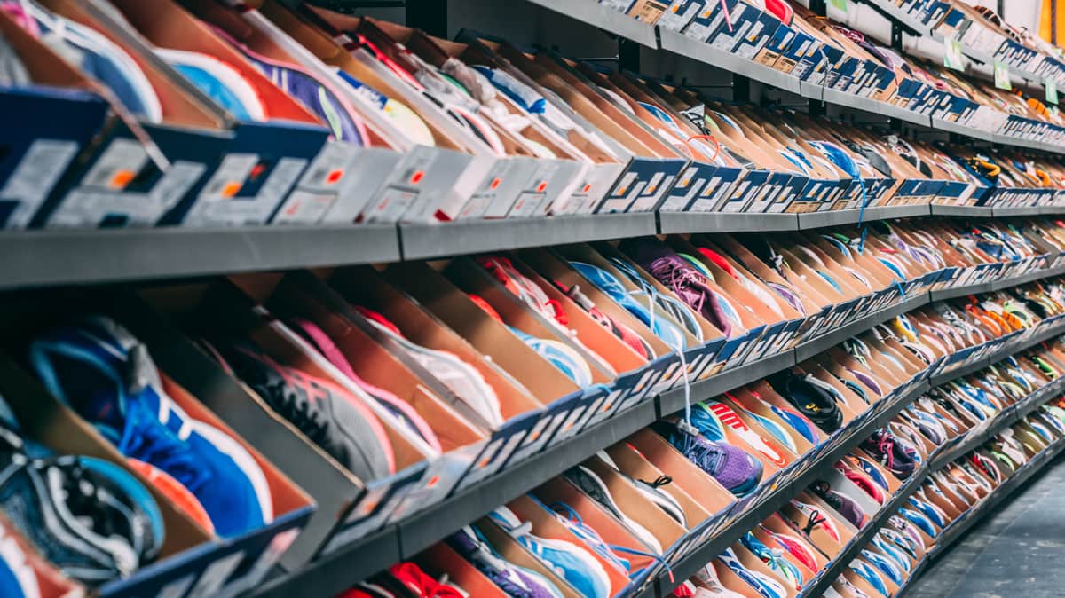 Rows of running shoes on shelves in a shoe store