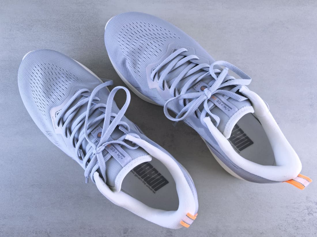 A pair of light gray running shoes seen from above