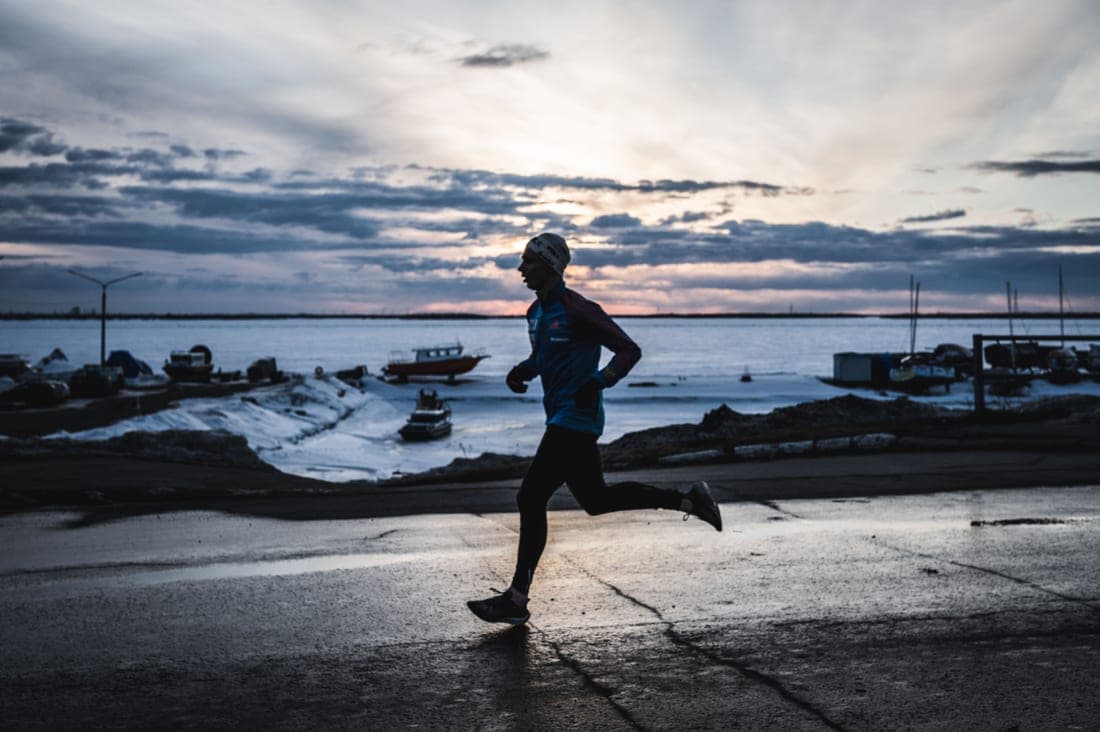 A runner on a waterfront path at dusk