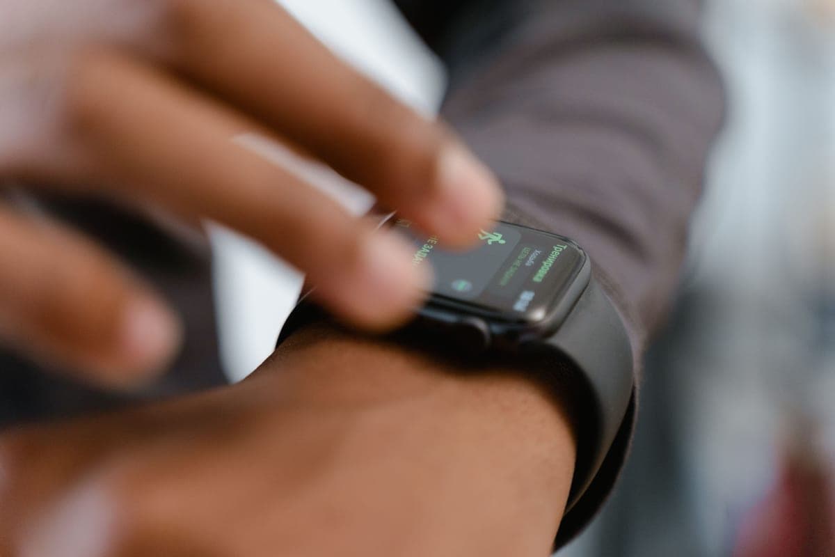 Close-up of a hand pressing a button on a smartwatch